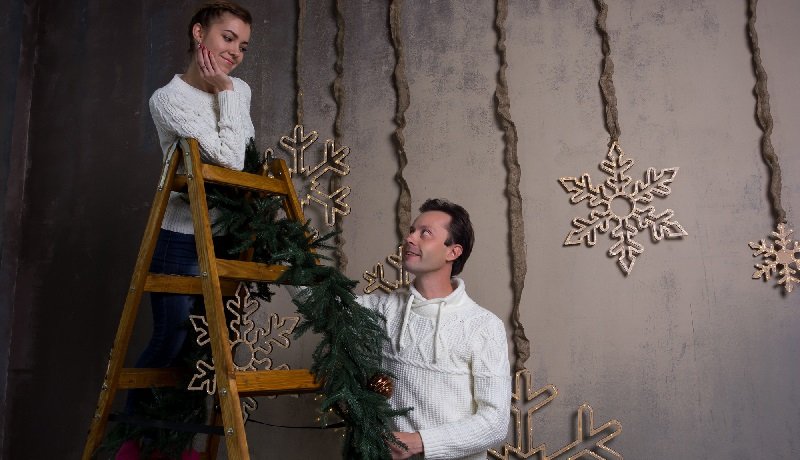пара украшает помещение к Новому Году