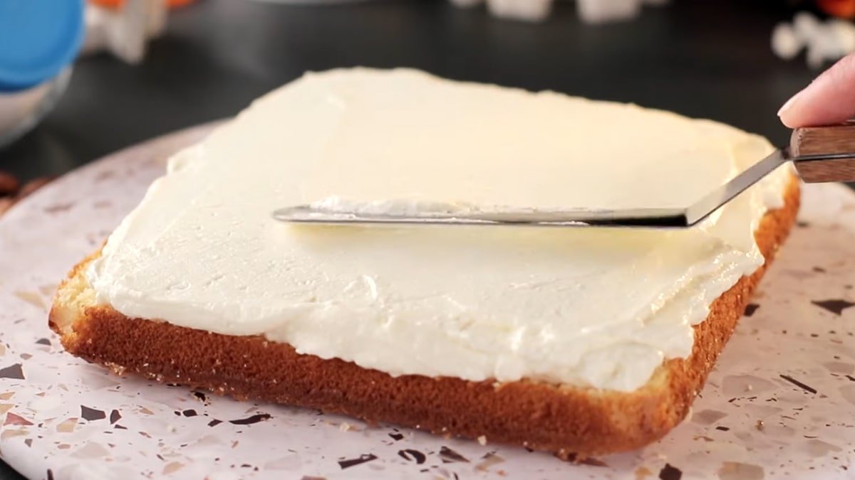 смазанный кремом нижний корж торта