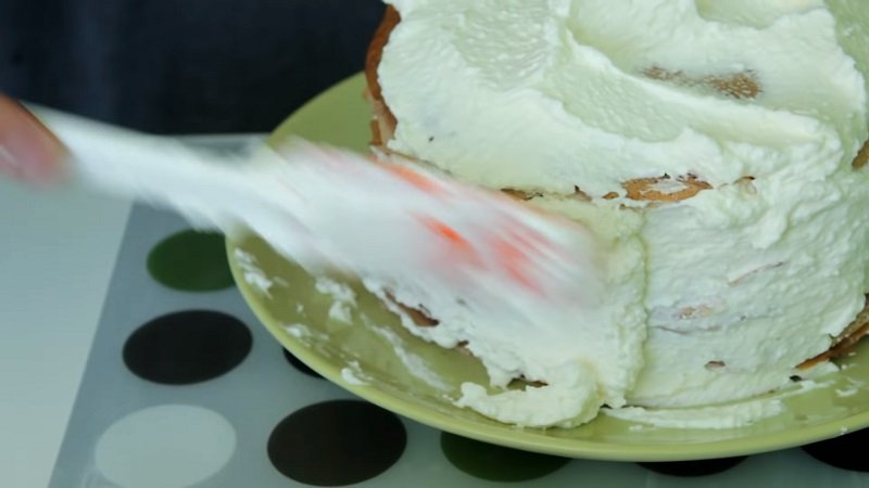 смазывает торт кремом