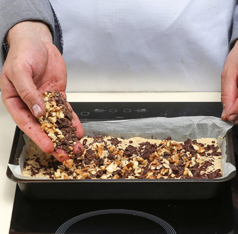 шоколад и грецкие орехи на готовом корже