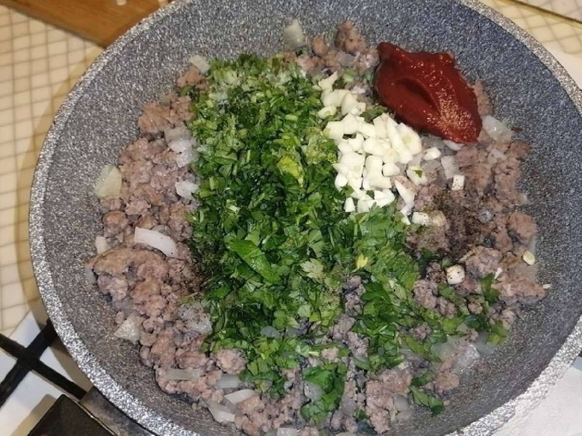 добавление петрушки, томатной пасты и чеснока