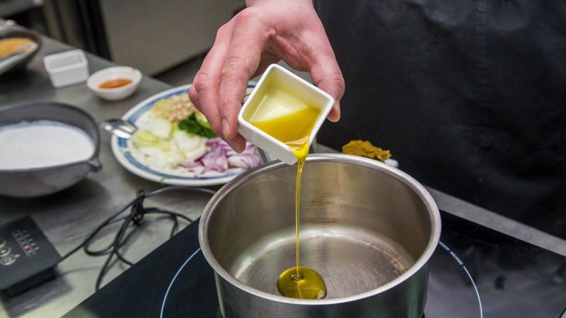 выливание масла в кастрюлю